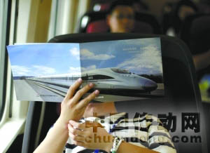 運(yùn)行的高鐵列車上，一名記者在看材料。